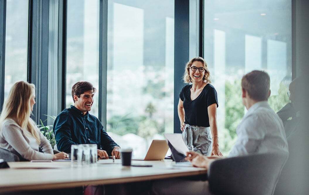People laughing around a meeting room table